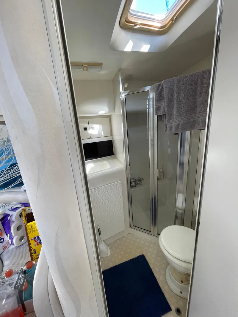Slide: The Image of 1993 Silverton 38 Express yacht bathroom with shower, toilet, and skylight. - 16
