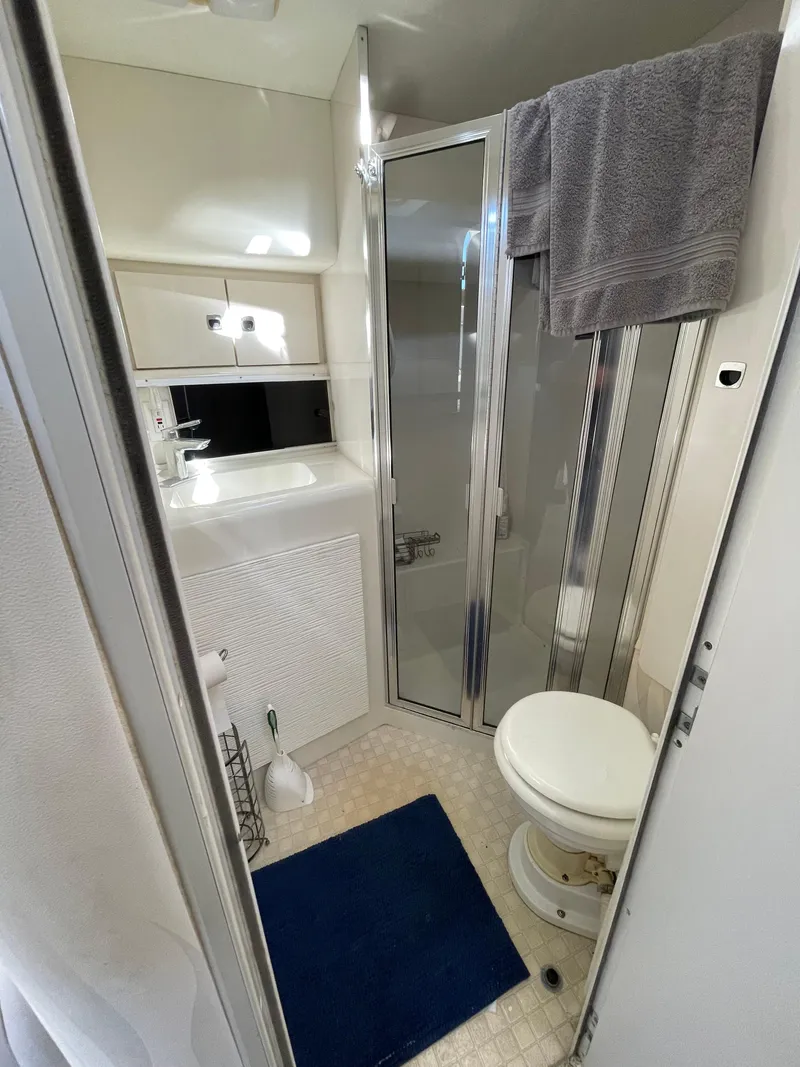 Slide: The Image of 1993 Silverton 38 Express yacht bathroom with shower, sink, and toilet. - 17