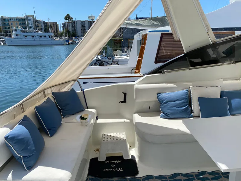 Slide: The Image of 1993 Silverton 38 Express yacht interior with blue cushions docked at marina. - 20
