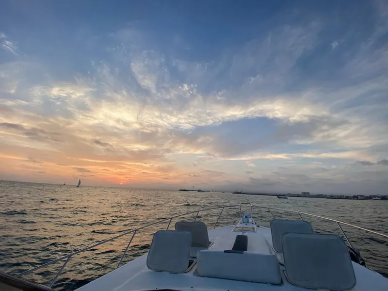 Slide: The Image of 1993 Silverton 38 Express yacht at sunset on the open sea. - 4