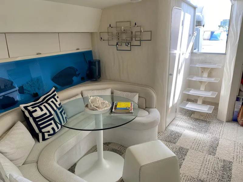 Slide: The Image of Interior of 1993 Silverton 38 Express yacht with modern white seating and glass table. - 6