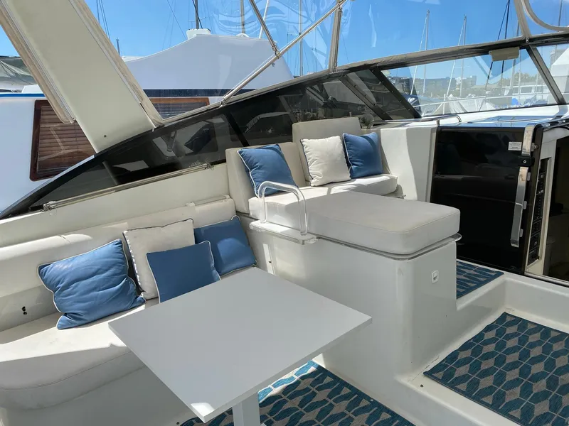 Slide: The Image of Interior of 1993 Silverton 38 Express yacht with cushioned seating and table. - 8