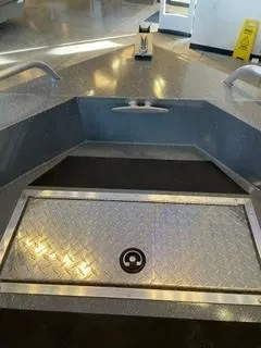 Slide: The Image of 2024 Spartan 200 Astoria boat interior with diamond plate flooring and storage compartment. - 1