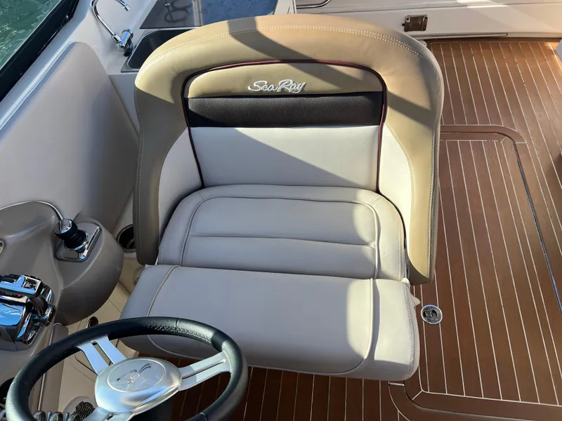 Slide: The Image of 2012 Sea Ray 300 SLX boat interior with beige captain's seat and wooden flooring. - 17
