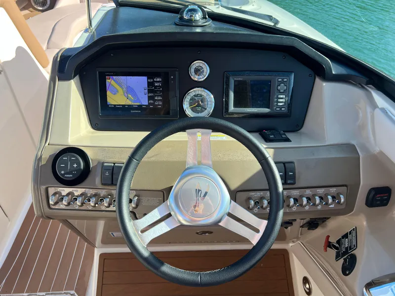 Slide: The Image of 2012 Sea Ray 300 SLX boat dashboard with steering wheel and navigation controls. - 18