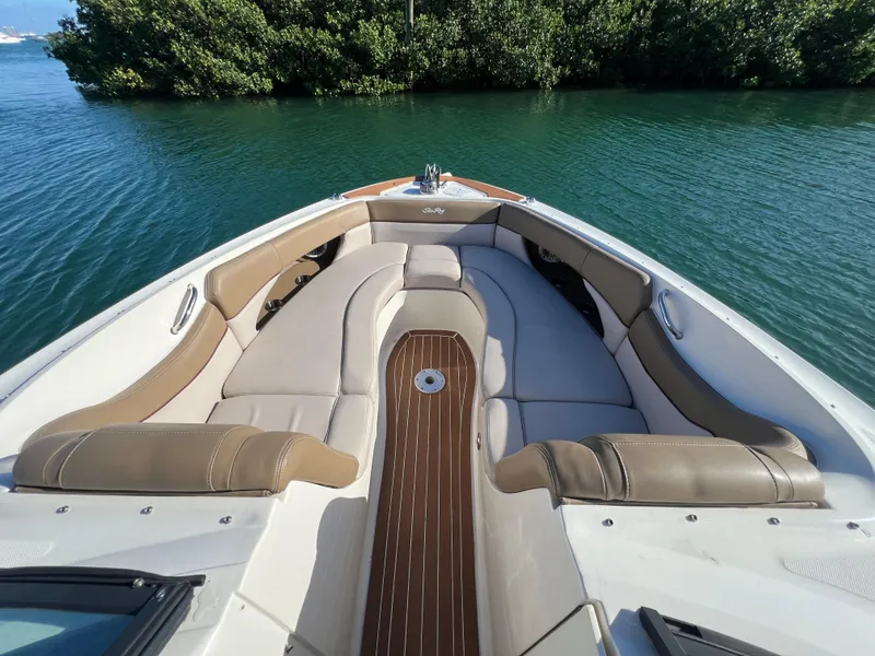 Slide: The Image of 2012 Sea Ray 300 SLX boat interior with cushioned seating on calm water. - 28