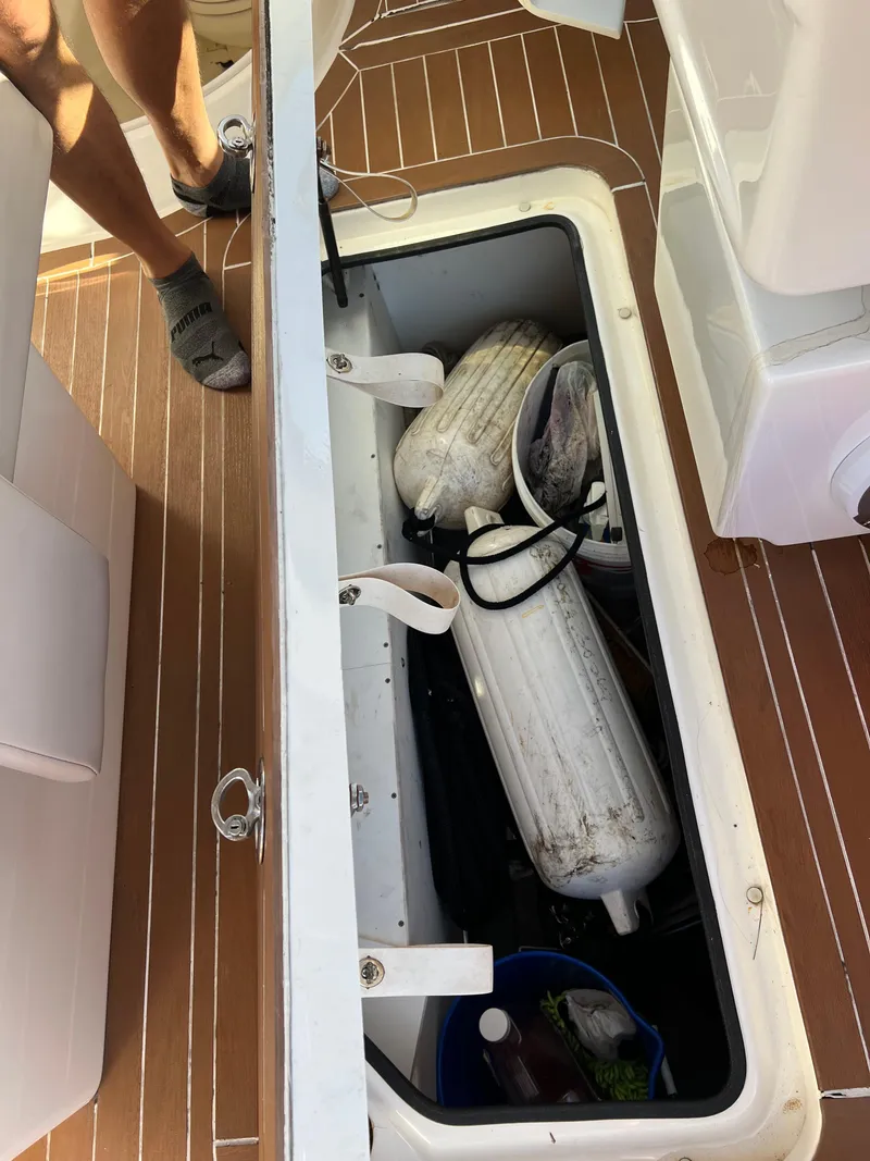 Slide: The Image of Open storage compartment on 2012 Sea Ray 300 SLX boat with fenders and supplies. - 41