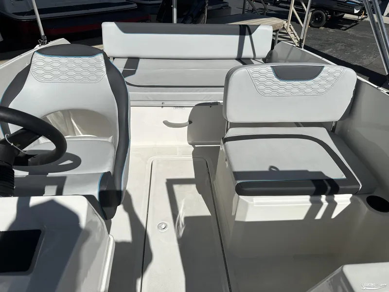 Slide: The Image of 2024 Bayliner M19 boat interior with modern seating and steering wheel. - 9