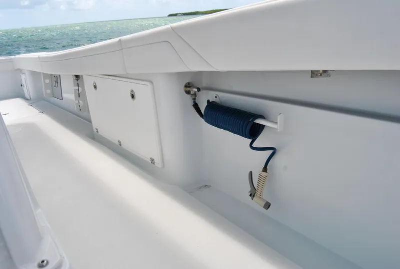 Slide: The Image of 2022 Yellowfin 39 Offshore boat deck with storage compartments and coiled hose. - 30