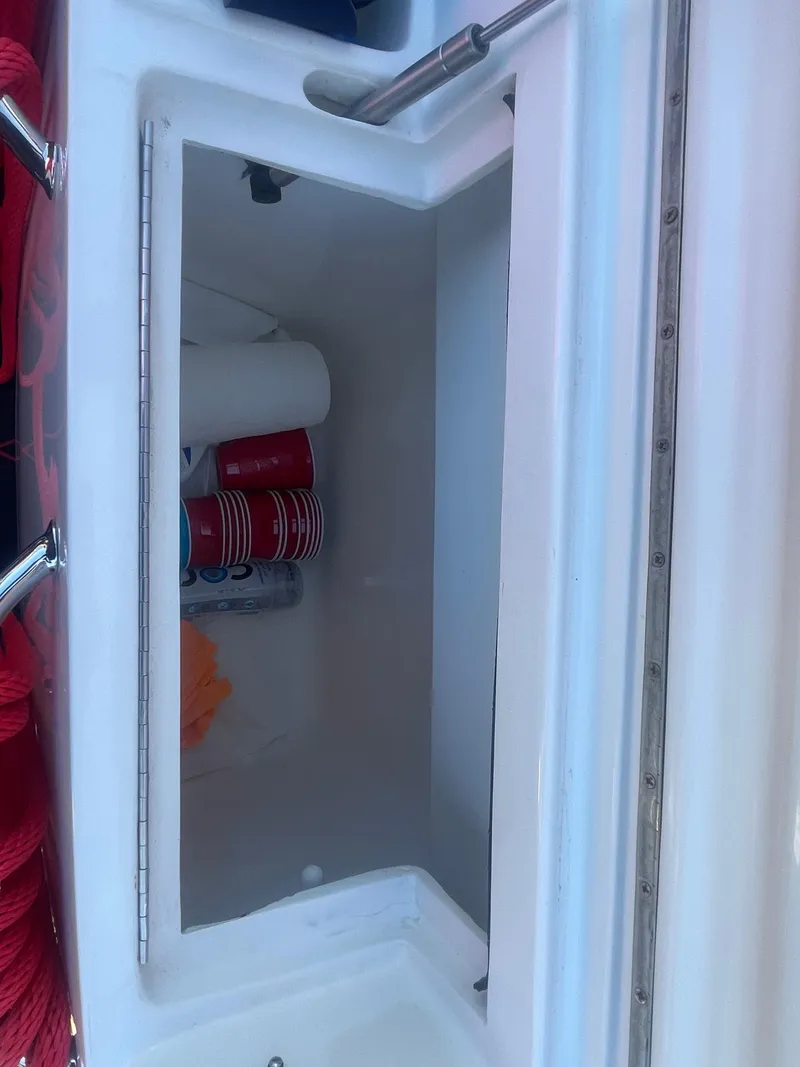 Slide: The Image of Storage compartment on a 2008 Deep Impact 36di boat with red cups and paper towels. - 22