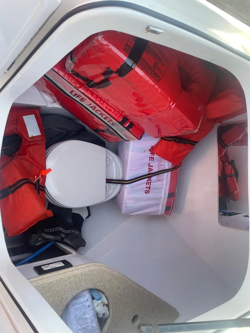 Slide: The Image of Storage area with life jackets and a toilet on a 2008 Deep Impact 36di boat. - 25