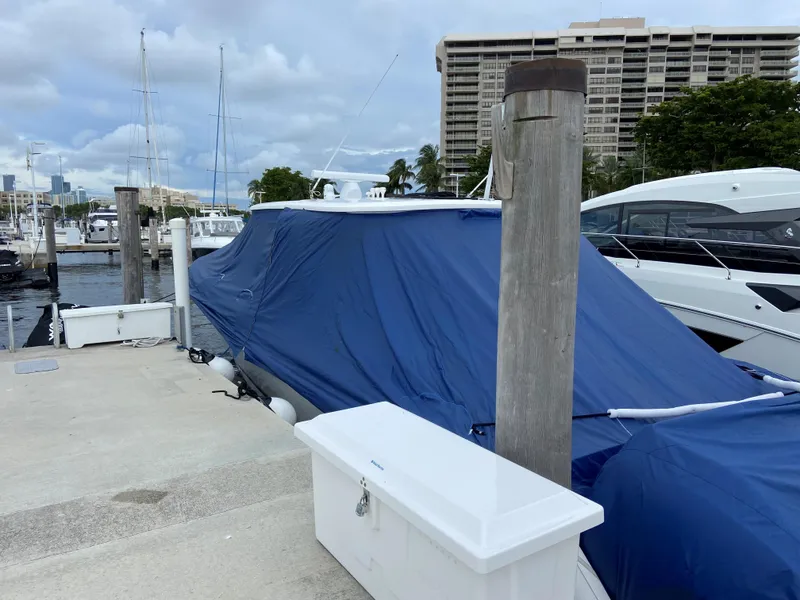 Slide: The Image of 2016 Intrepid 475 Panacea boat covered with blue tarp at marina dock. - 18