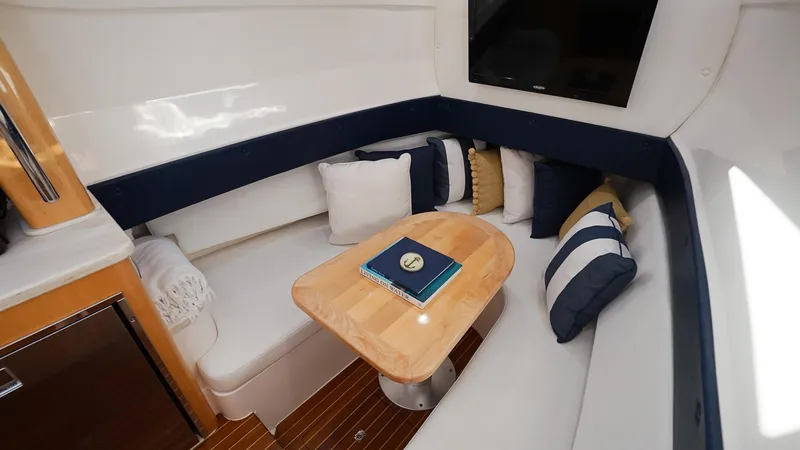 Slide: The Image of 2016 Intrepid 475 Panacea cabin with cozy seating and wooden table. - 22