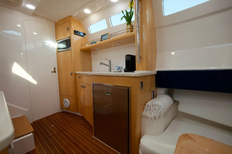 Slide: The Image of 2016 Intrepid 475 Panacea interior with modern kitchen, wooden cabinetry, and natural light. - 25