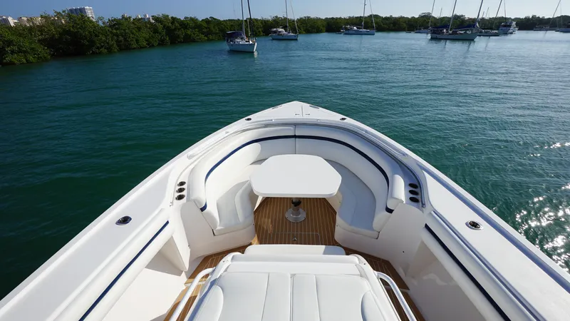 Slide: The Image of 2016 Intrepid 475 Panacea boat bow with seating and table on calm water. - 9