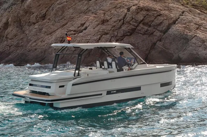 The Image of 2024 De Antonio Yachts D32 OPEN cruising near rocky coastline. - 0