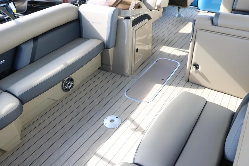 Slide: The Image of 2025 Sylvan Mirage X3 Party Fish boat interior with beige seating and wood-like flooring. - 18
