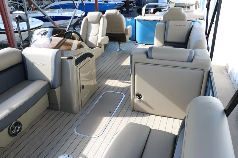 Slide: The Image of 2025 Sylvan Mirage X3 Party Fish pontoon boat interior with beige seating and modern amenities. - 19