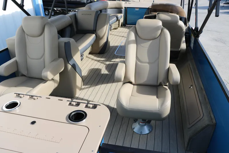 Slide: The Image of 2025 Sylvan Mirage X3 Party Fish boat interior with beige seating and table. - 23