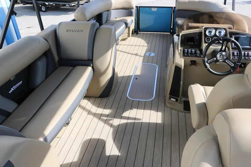 Slide: The Image of 2025 Sylvan Mirage X3 Party Fish pontoon boat interior with beige seating and modern dashboard. - 26