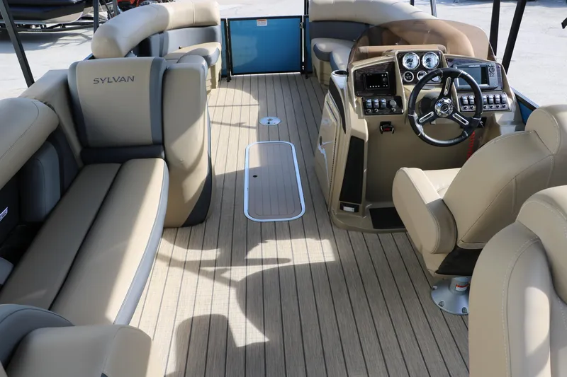 Slide: The Image of 2025 Sylvan Mirage X3 Party Fish boat interior with beige seating and modern dashboard. - 27