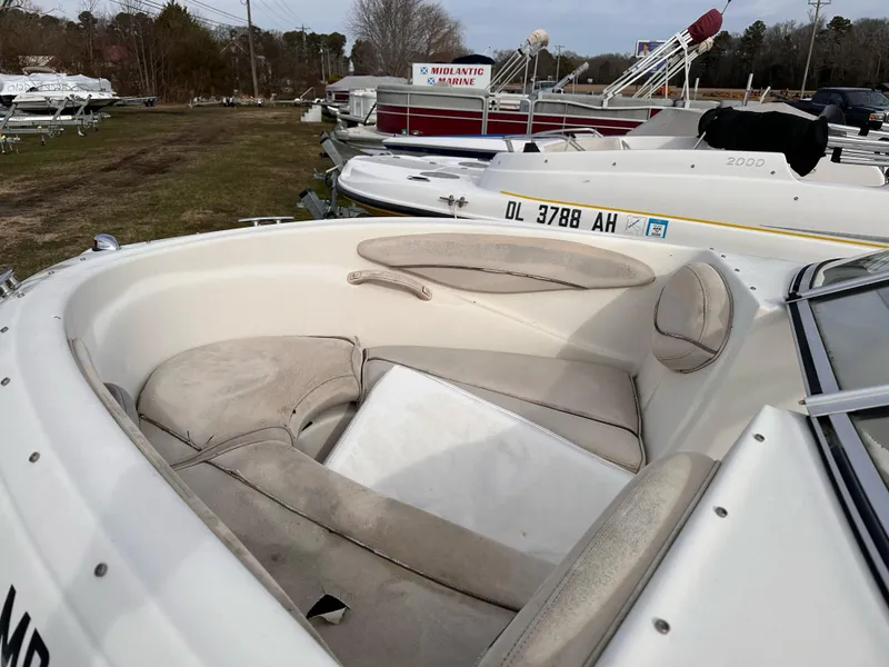 Slide: The Image of 2000 Maxum Bowrider boat with spacious seating, docked among other boats. - 2