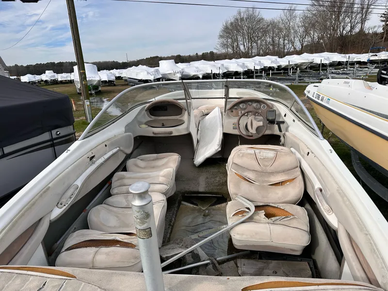 Slide: The Image of 2000 Maxum Bowrider boat with worn interior seats in a storage yard. - 3