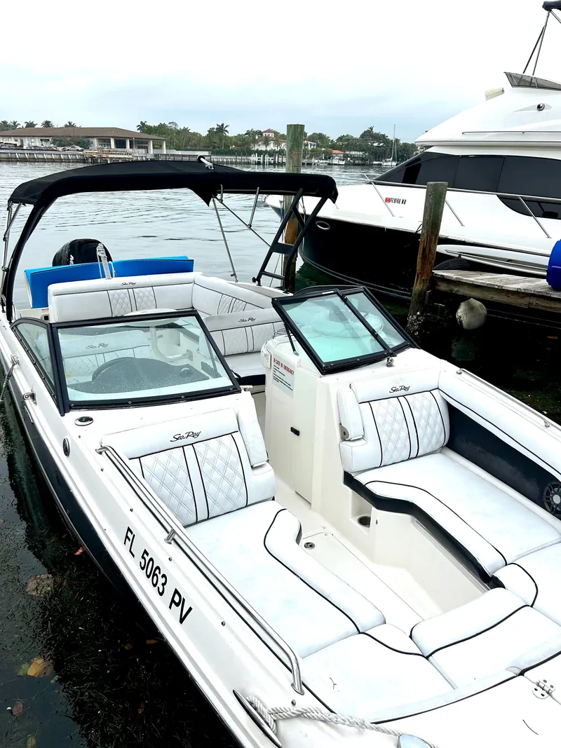 Slide: The Image of 2015 Sea Ray SDX 270 boat docked, featuring spacious seating and sleek design. - 28