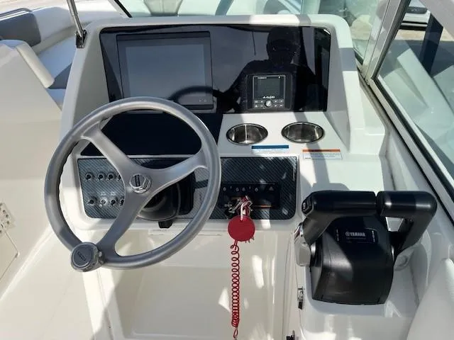 Slide: The Image of 2022 World Cat 230 SD boat helm with steering wheel, controls, and display screens. - 26