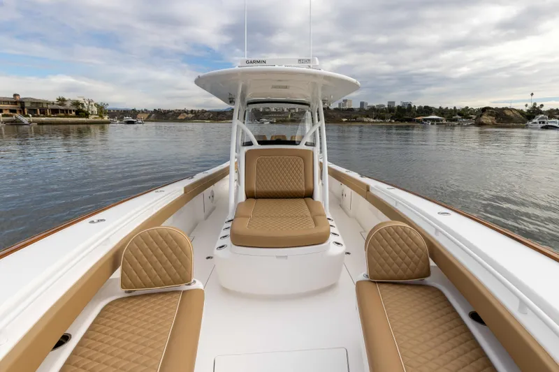 Slide: The Image of 2021 Valhalla Boatworks V37 with tan seating on a calm waterway. - 2