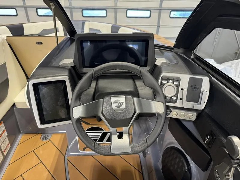 Slide: The Image of 2024 Malibu 23 LSV boat dashboard with steering wheel and touchscreen controls. - 11
