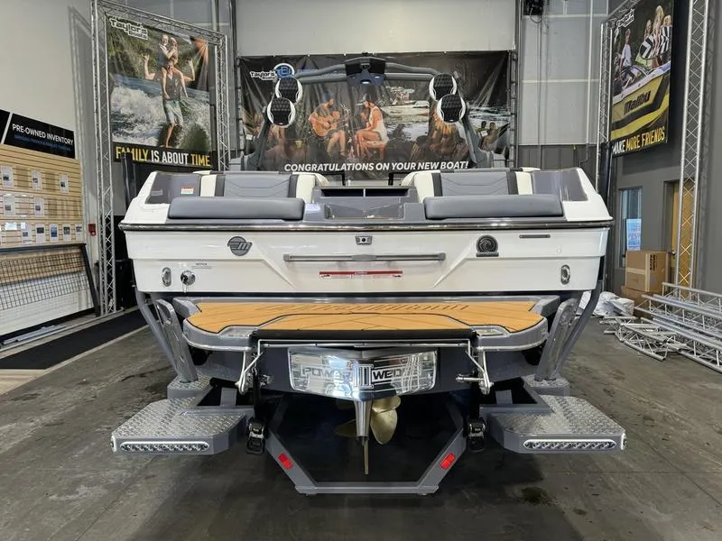 Slide: The Image of 2024 Malibu 23 LSV boat in showroom, rear view with swim platform and speakers. - 4