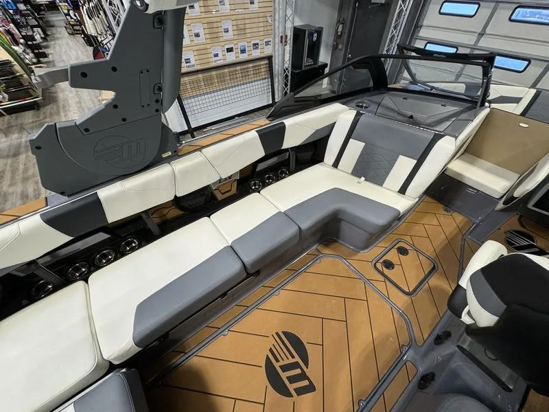 Slide: The Image of 2024 Malibu 23 LSV boat interior with white and gray seating, and teak flooring. - 7