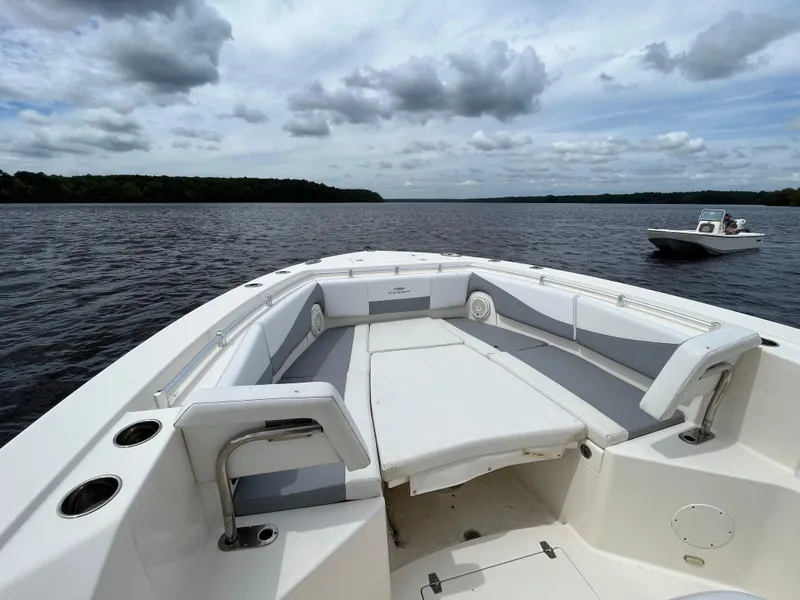 Slide: The Image of 2019 Cobia 320 CC boat on a calm lake under cloudy skies. - 11