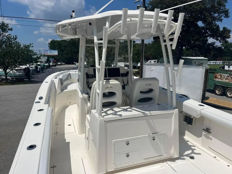 Slide: The Image of 2019 Cobia 320 CC boat with center console and seating, parked outdoors. - 15