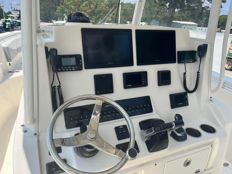 Slide: The Image of 2019 Cobia 320 CC boat dashboard with steering wheel and electronic controls. - 19