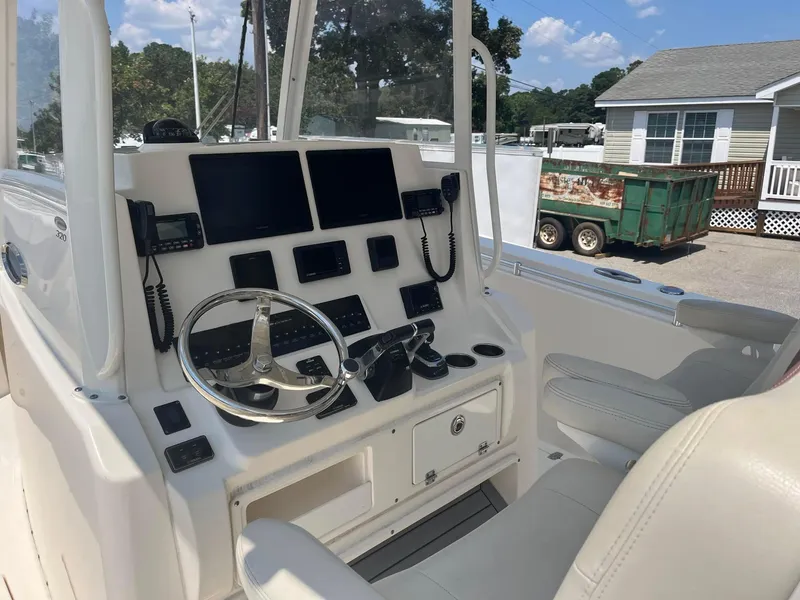 Slide: The Image of 2019 Cobia 320 CC boat cockpit with modern navigation equipment and steering wheel. - 20