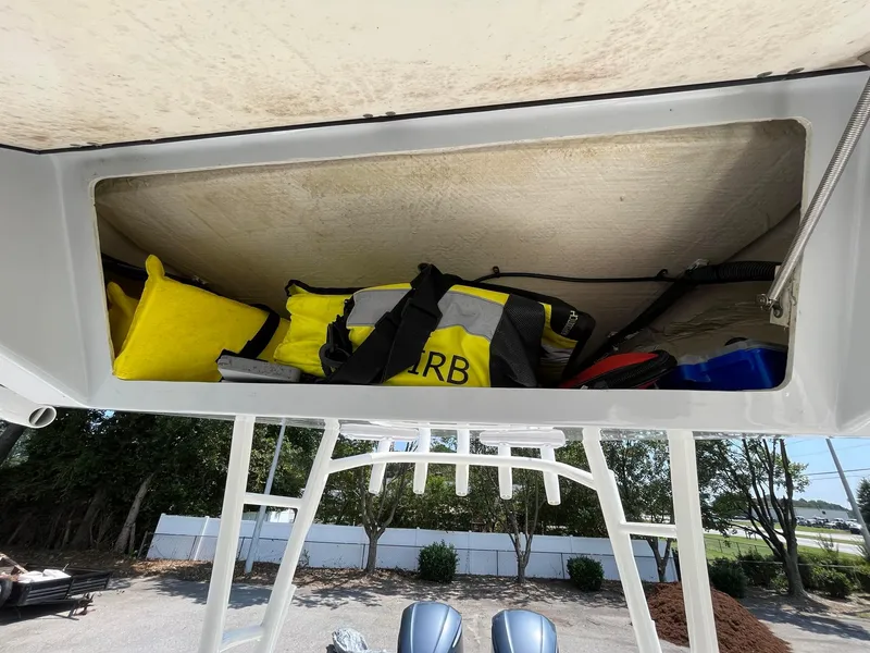 Slide: The Image of Storage compartment on a 2019 Cobia 320 CC boat with safety gear and equipment. - 21