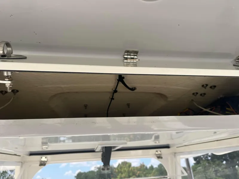 Slide: The Image of Open storage compartment on 2019 Cobia 320 CC boat, showing interior wiring. - 22