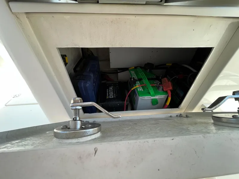 Slide: The Image of Battery compartment of a 2019 Cobia 320 CC boat, showing marine battery setup. - 24