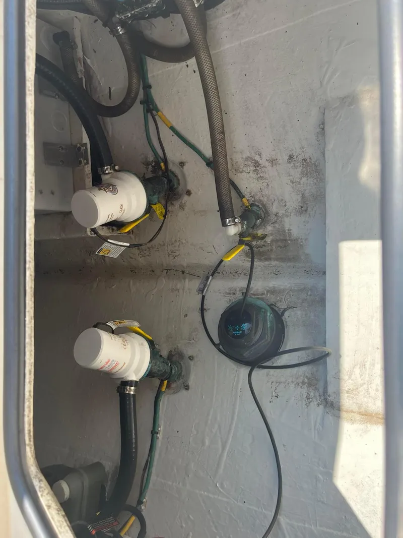 Slide: The Image of 2019 Cobia 320 CC boat bilge area with pumps and wiring. - 25