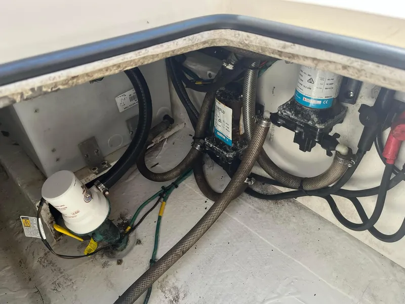 Slide: The Image of 2019 Cobia 320 CC boat engine compartment with hoses and filters. - 27