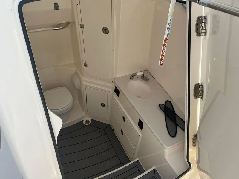 Slide: The Image of Interior of 2019 Cobia 320 CC boat bathroom with toilet and sink. - 28
