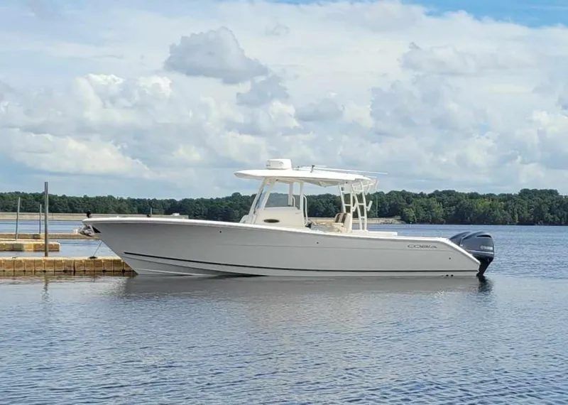 Slide: The Image of 2019 Cobia 320 CC boat on calm water under cloudy sky. - 3
