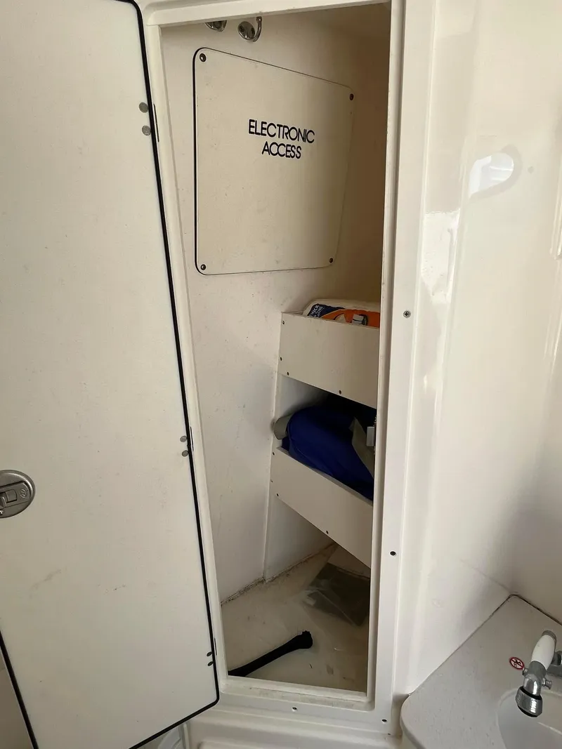 Slide: The Image of 2019 Cobia 320 CC electronic access compartment with storage shelves. - 30
