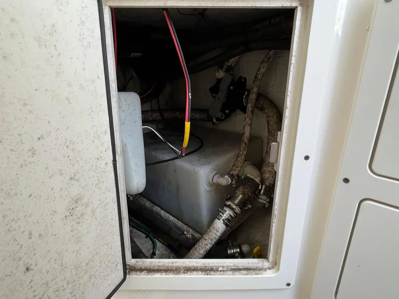 Slide: The Image of 2019 Cobia 320 CC boat compartment with wiring and hoses visible. - 32
