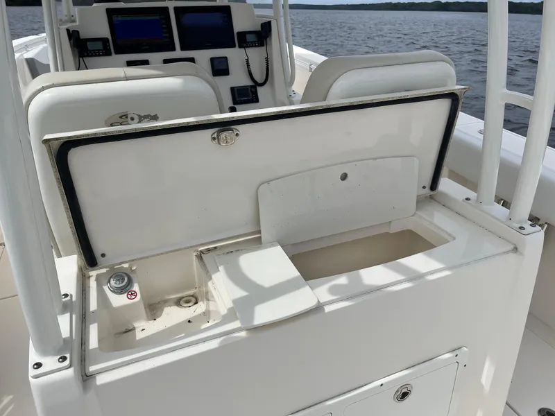 Slide: The Image of 2019 Cobia 320 CC boat console with open storage compartment, featuring navigation equipment. - 41
