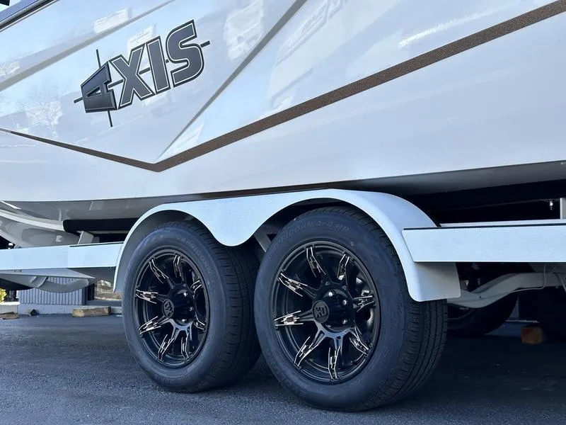 Slide: The Image of 2024 Axis T250 boat on a dual-axle trailer with black alloy wheels. - 3