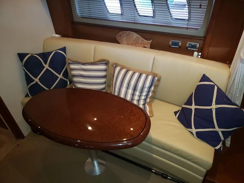 Slide: The Image of Interior seating area of 2008 Sea Ray 38 Sundancer with cushions and wooden table. - 25