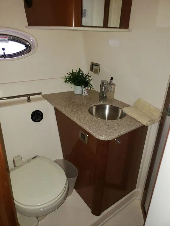 Slide: The Image of 2008 Sea Ray 38 Sundancer bathroom with sink, toilet, and porthole window. - 3
